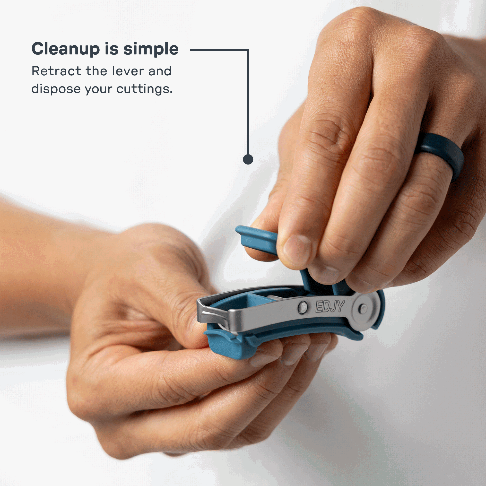 A man retracts the teal lever on an EDJY toenail cutter to reveal the internal chamber, showing how simple it is to dispose of nail cuttings.